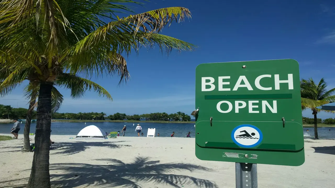 A sign indicating the beach is open.